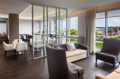 a living room with a couch and a table and chairs at Hilton Miami Aventura in Aventura