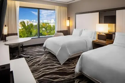 a hotel room with two beds and a large window at Hilton Miami Aventura in Aventura