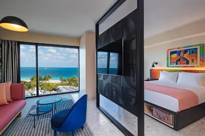 a bedroom with a bed and a view of the ocean at Moxy Miami South Beach in Miami Beach