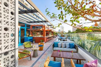 a patio with couches and tables on a building at Moxy Miami South Beach in Miami Beach