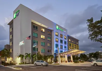 a hotel with cars parked in a parking lot at Holiday Inn Express Doral Miami by IHG in Doral