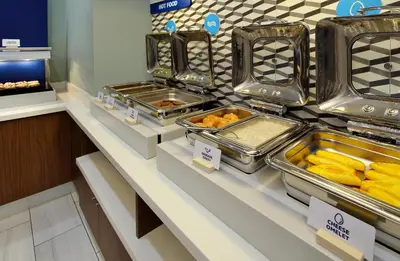 a buffet line with trays of food on display at Holiday Inn Express Doral Miami by IHG in Doral