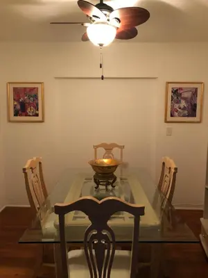 a dining room with a glass table and a ceiling fan at Beautiful Quiet Neighborhood in Miami