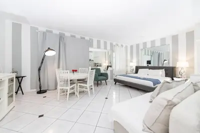 a bedroom with a bed and a table and chairs at Apartments on Collins in Miami Beach