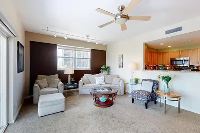 a living room with white furniture and a ceiling fan at Paradise Perch in Fort Lauderdale