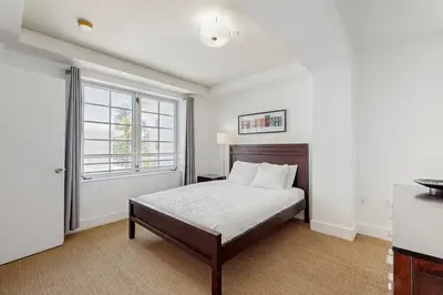 a white bedroom with a bed and a window at The Carlyle 3G in Miami Beach
