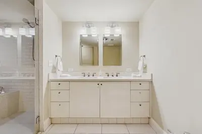 a white bathroom with a sink and a mirror at The Carlyle 3G in Miami Beach