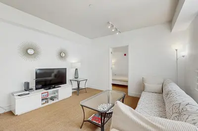a white living room with a couch and a tv at The Carlyle 3G in Miami Beach