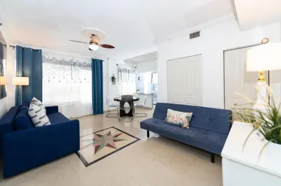 a living room with two blue couches and a table at Apartments on Ocean Drive in Miami Beach