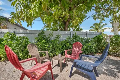 four chairs and a table in front of a fence at Casa Nikoleta Gated 3Bd 2Bth 10 Min to Beach in Miami