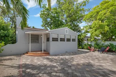 a white house with two chairs and a patio at Casa Nikoleta Gated 3Bd 2Bth 10 Min to Beach in Miami