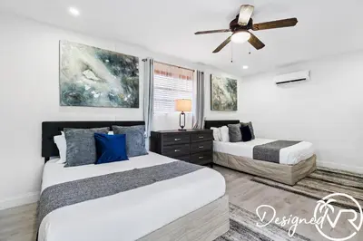 a bedroom with two beds and a ceiling fan at 4BR retreat w heated pool backyard BBQ grill in Dania Beach