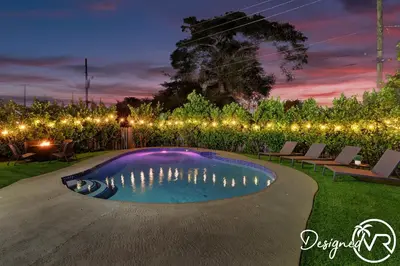a swimming pool in a yard with lights at 4BR retreat w heated pool backyard BBQ grill in Dania Beach