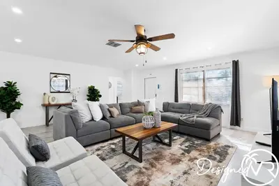 a living room with a couch and a ceiling fan at 4BR retreat w heated pool backyard BBQ grill in Dania Beach