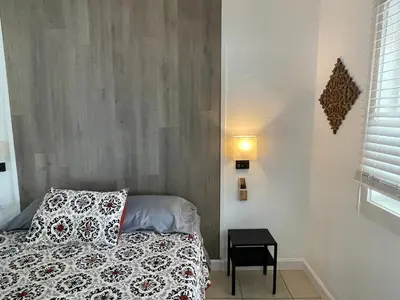 a small bedroom with a bed and a side table at Cozy Studio near Coconut Grove in Miami