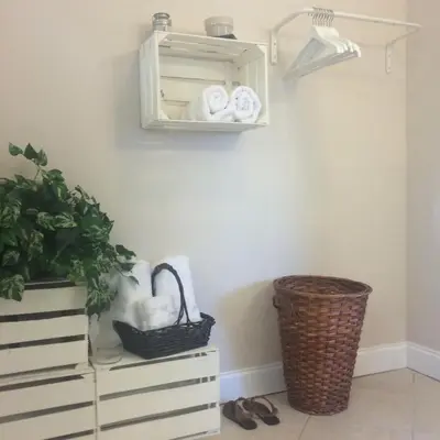 a shelf above a dresser with towels and a plant at Chic and Comfortable Studio Free Street Parking in Miami