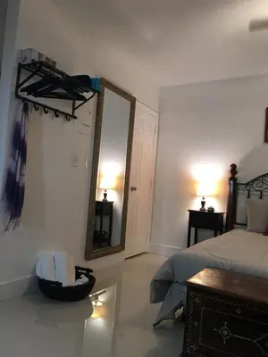 a bedroom with a mirror and a bed and a chair at Private Studio blocks from Coconut Grove in Miami