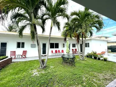 a house with palm trees and a table in the yard at Private Studio blocks from Coconut Grove in Miami