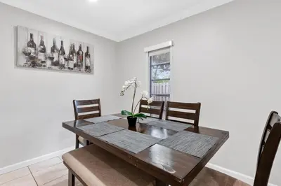a dining room with a wooden table and chairs at The Home in The Oaks - By Avi in Fort Lauderdale
