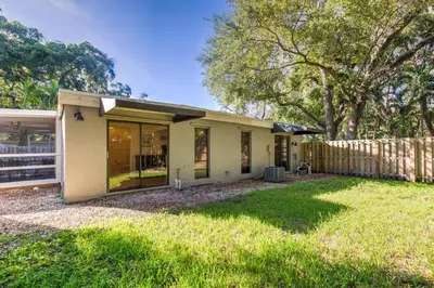 a small white house with a fence in a yard at The Home in The Oaks - By Avi in Fort Lauderdale