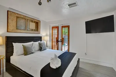 a bedroom with a large bed with a tv on the wall at Family home wpool tiki hut grill in Hollywood