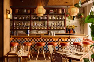 a restaurant with a bar with tables and chairs at Esme Miami Beach in Miami Beach