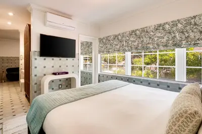 a bedroom with a large white bed and windows at Esme Miami Beach in Miami Beach