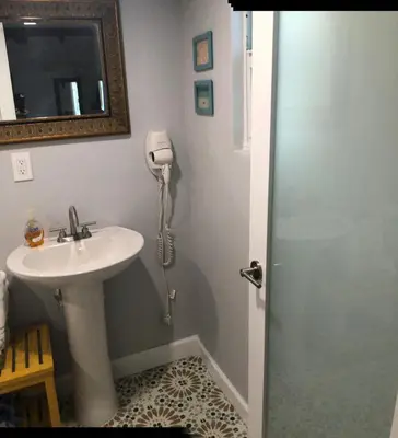 a bathroom with a sink and a phone on the wall at Private Studio Cabin steps from Calle 8 in Miami