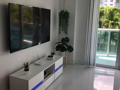a living room with a large flat screen tv on a wall at The Blue Island in Miami Beach