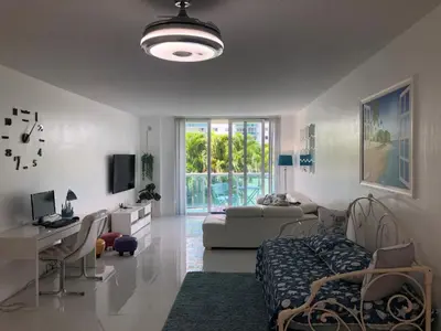 a living room with a couch and a table and a desk at The Blue Island in Miami Beach