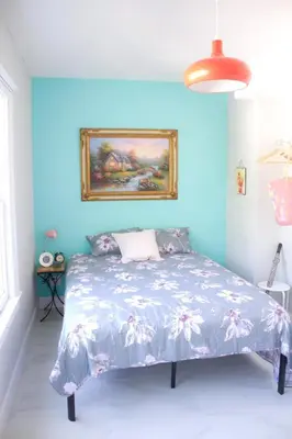 a bedroom with a bed with a blue wall at Cozy Aqua Private Suite with Parking in Miami