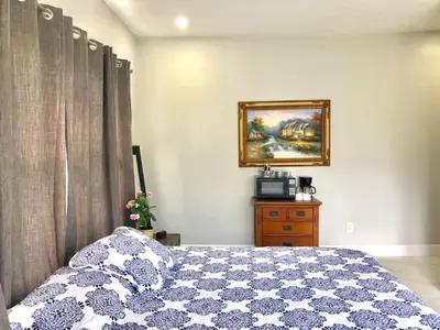 a bedroom with a bed and a picture on the wall at Sunny and Charming Suite next to MIA in Miami