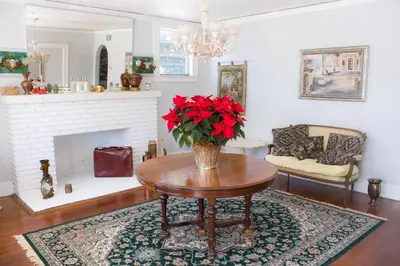 a living room with a table with red flowers on it at Sunny and Charming Suite next to MIA in Miami
