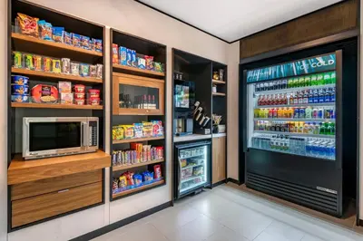 a kitchen with a refrigerator and a television and food at Courtyard by Marriott Fort Lauderdale Downtown in Fort Lauderdale