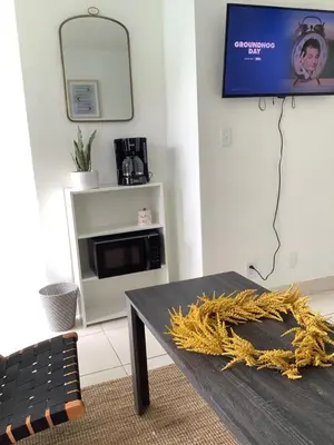 a living room with a table and a tv at Hotel Motel Lauderdale Inn in Fort Lauderdale