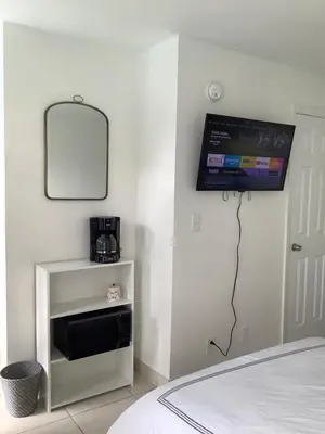a bedroom with a tv on the wall next to a bed at Hotel Motel Lauderdale Inn in Fort Lauderdale
