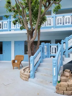 a blue staircase in front of a building with a tree at Hotel Motel Lauderdale Inn in Fort Lauderdale
