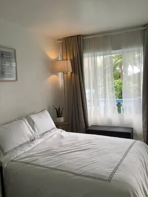 a bedroom with a white bed and a window at Hotel Motel Lauderdale Inn in Fort Lauderdale
