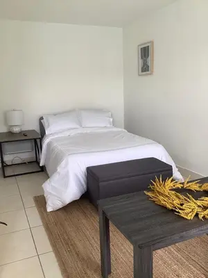 a bedroom with a white bed and a table at Hotel Motel Lauderdale Inn in Fort Lauderdale