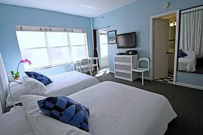 a hotel room with two beds and a television at 918 SOBE FLATS in Miami Beach