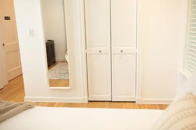 a bedroom with white cabinets and a mirror at Casa Coral in Miami