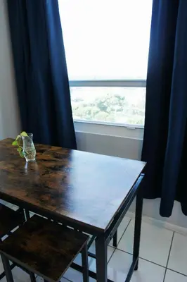 a wooden table with a chair in front of a window at Castle 705 in Miami Beach