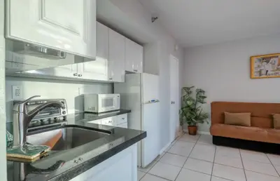 a kitchen with a sink and a couch in a room at Castle 705 in Miami Beach