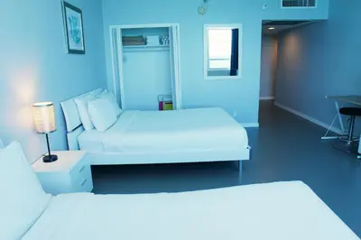 two white beds in a room with blue walls at Castle 835 Oceanview studio on beach with pool, gym, bars, and FREE Parking in Miami Beach