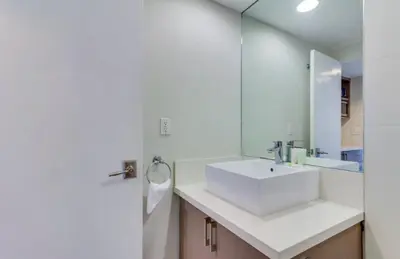 a bathroom with a white sink and a mirror at Castle 835 Oceanview studio on beach with pool, gym, bars, and FREE Parking in Miami Beach
