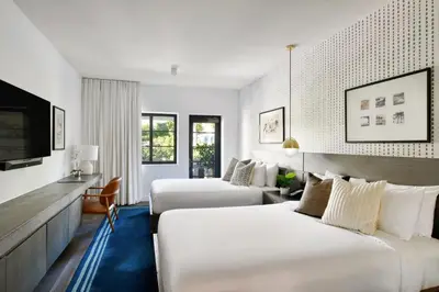 a hotel room with two beds and a tv at Kaskades Hotel South Beach in Miami Beach