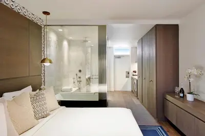 a bedroom with a white bed and a bath tub at Kaskades Hotel South Beach in Miami Beach