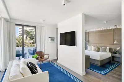 a hotel room with a bed and a tv at Kaskades Hotel South Beach in Miami Beach