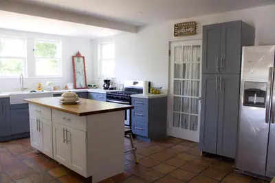 a kitchen with blue cabinets and a white refrigerator at Spacious and Comfy Suite near MIA 2 Queen Beds in Miami