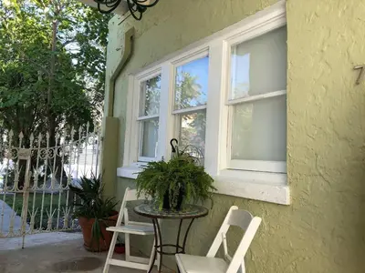 a table and chairs on a porch with two windows at Spacious and Comfy Suite near MIA 2 Queen Beds in Miami